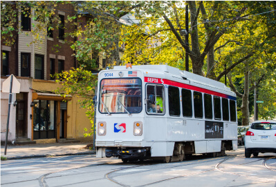 Trolley driving down the street during summer