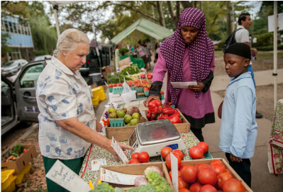 Family buying produce at the Clark Park farmers market