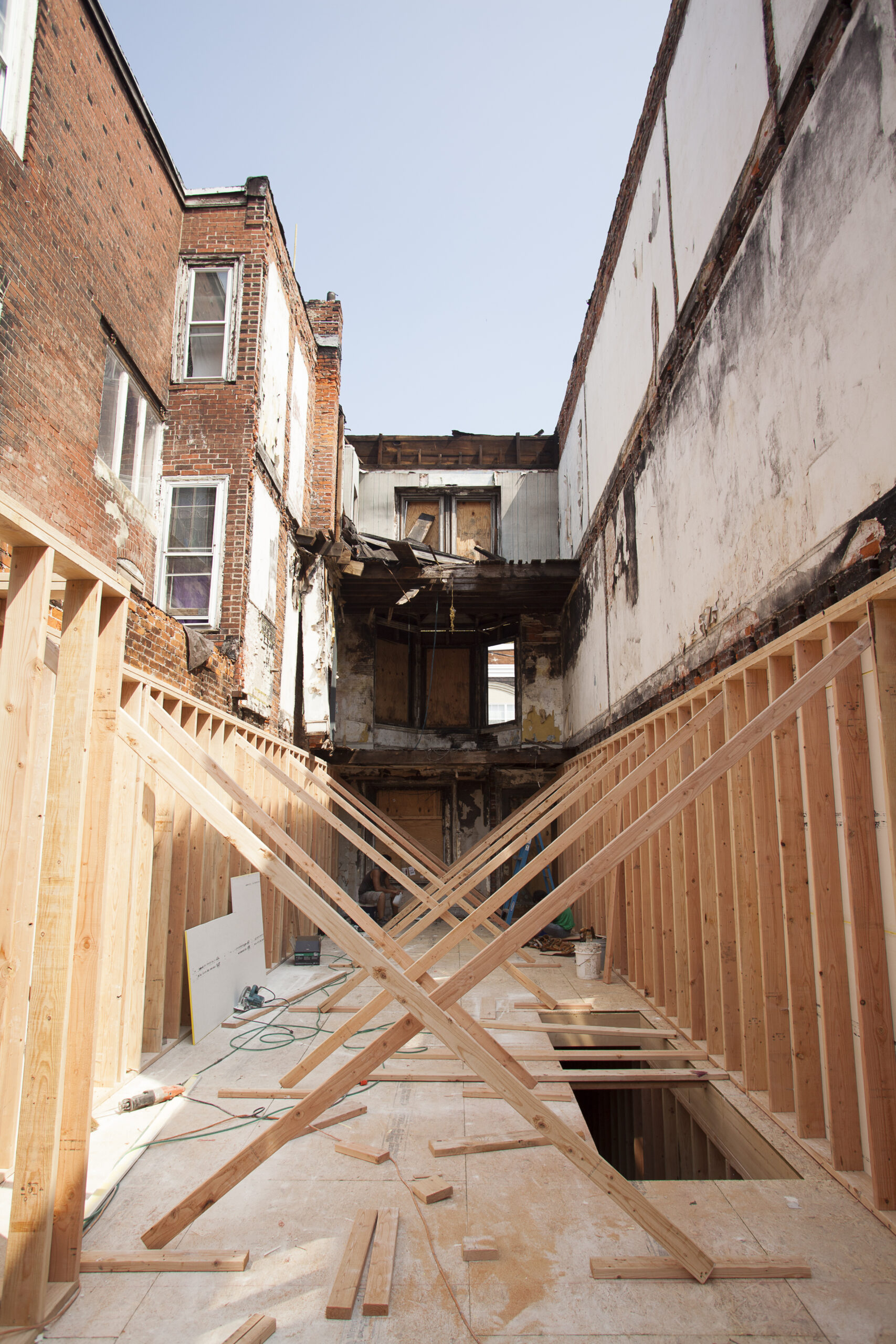 Interior view of a partially reconstructed building with wooden supports and framing during a rehabilitation project.