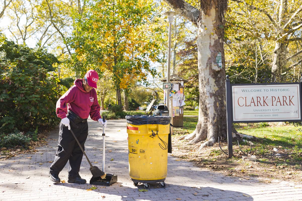 University City Public Space Maintenance member sweeping at Clark Park