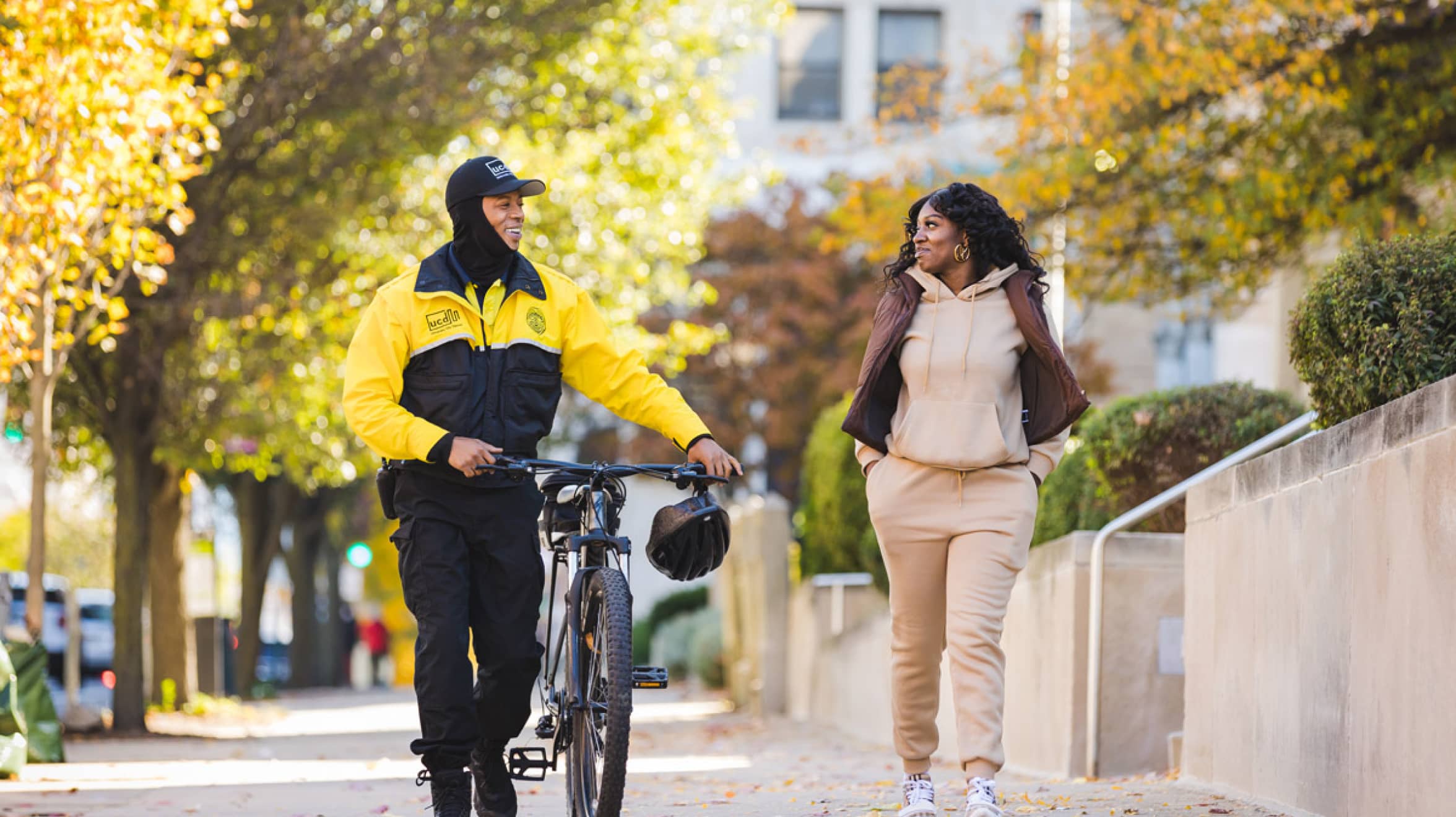 Safety ambassador and a community member walking and smiling on a sunny fall day