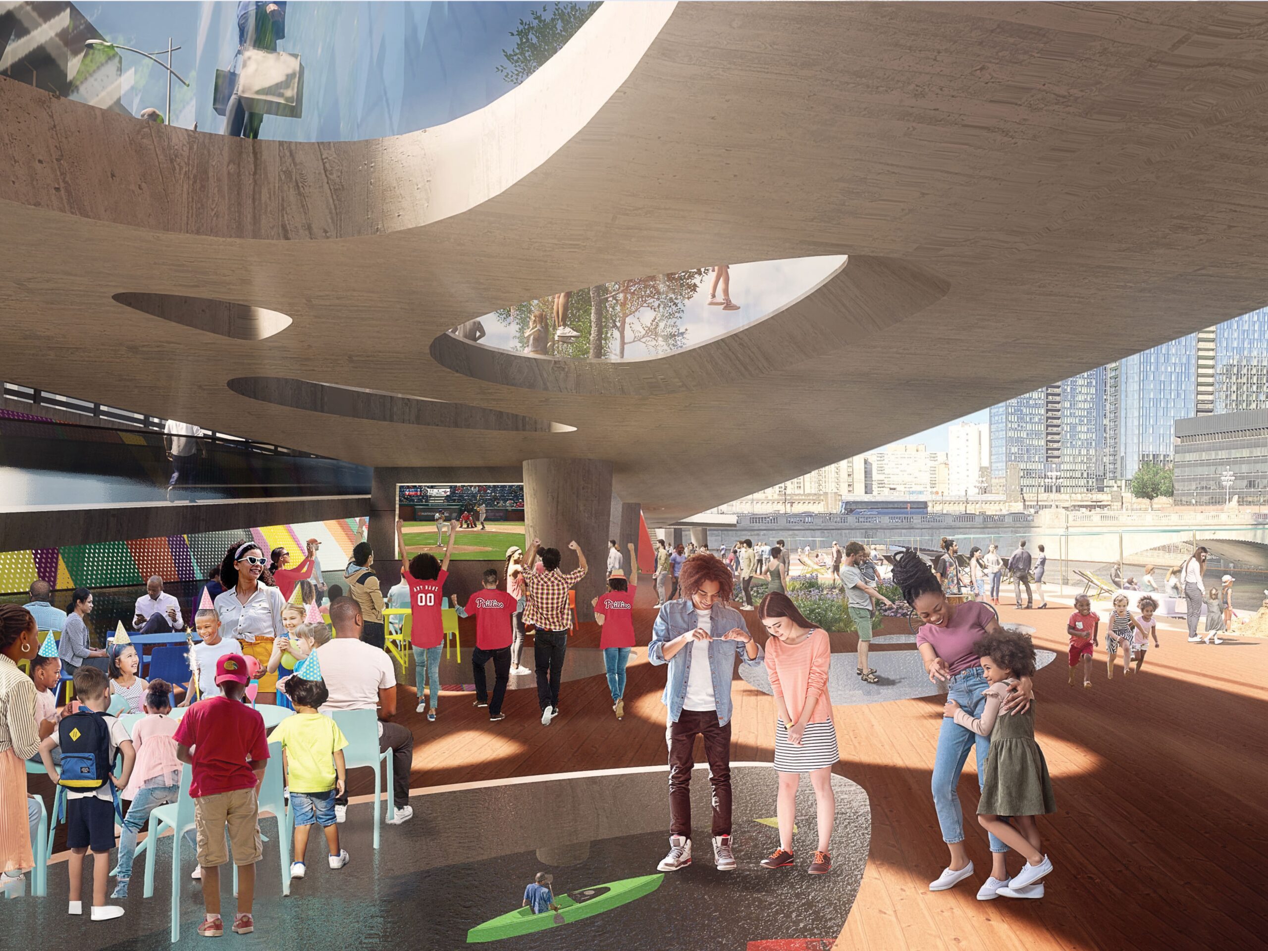 A rendering of a shaded community space under a modern structure at the West Philly Waterfront, showing families and children participating in activities with a backdrop of murals and river views.