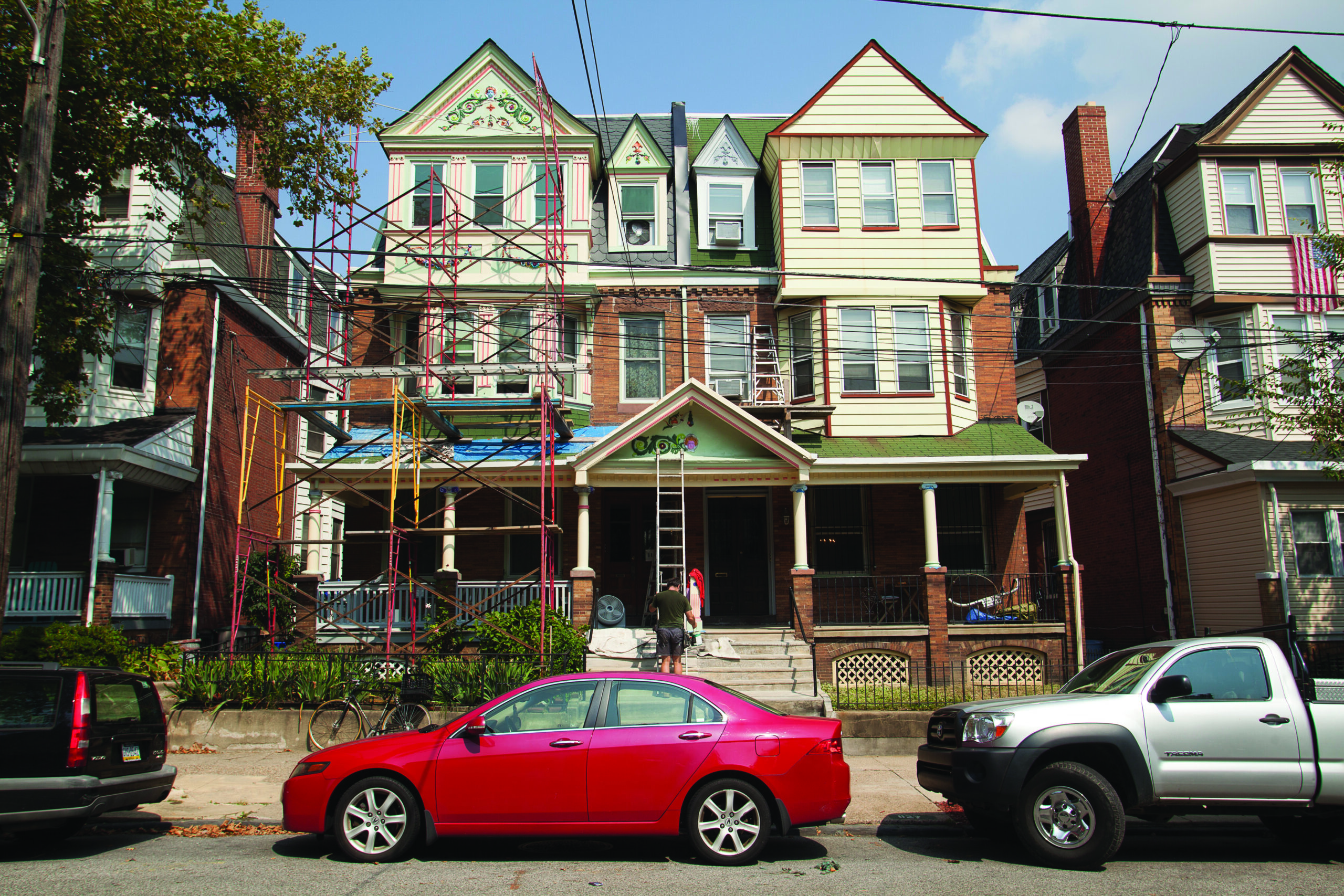 Front view of row homes with scaffolding and ladders during renovation.