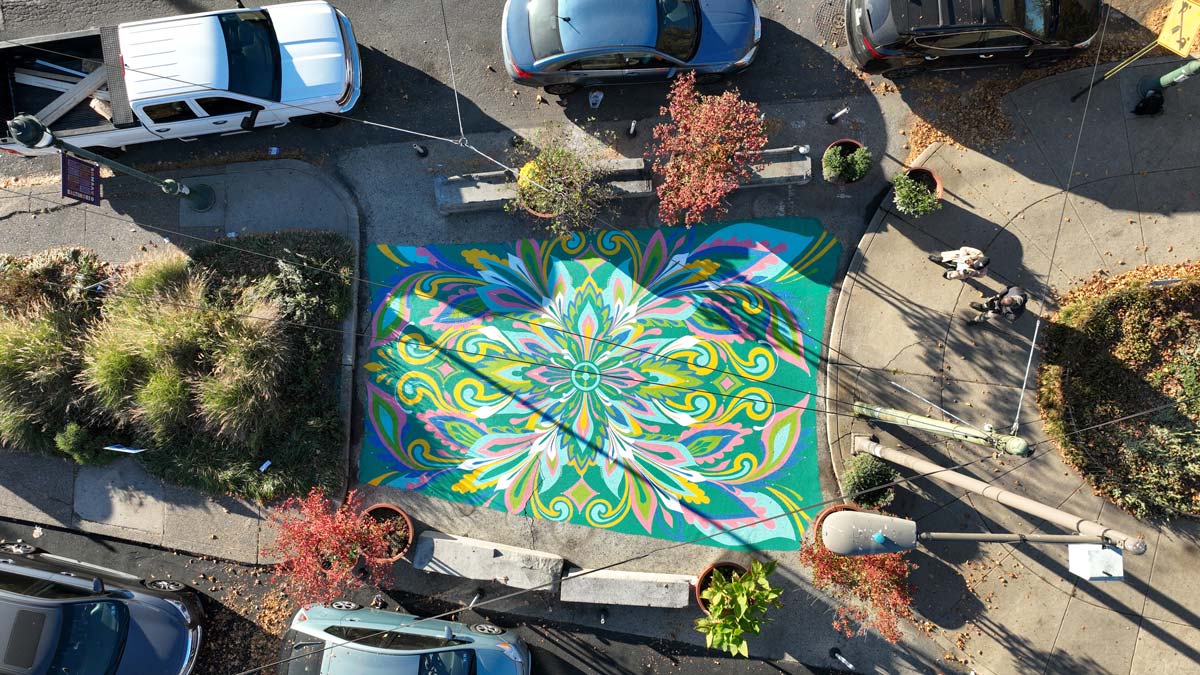 Aerial shot of Cedar Park Ground mural. Mural is abstract and floral, featuring jewel tones, pinks and yellows