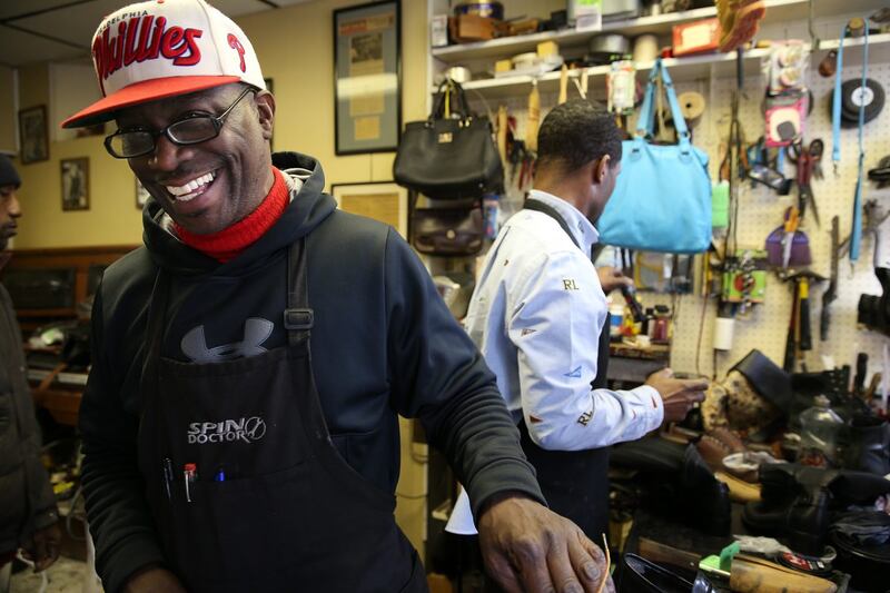 Jerry Burrell laughs as he and Terrence Banks repair shoes at Cliff's Shoe Shine on S. 40th Street in Philadelphia