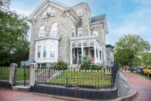 a beautiful old stone home with brick sidewalk on a corner lot in Powelton Village