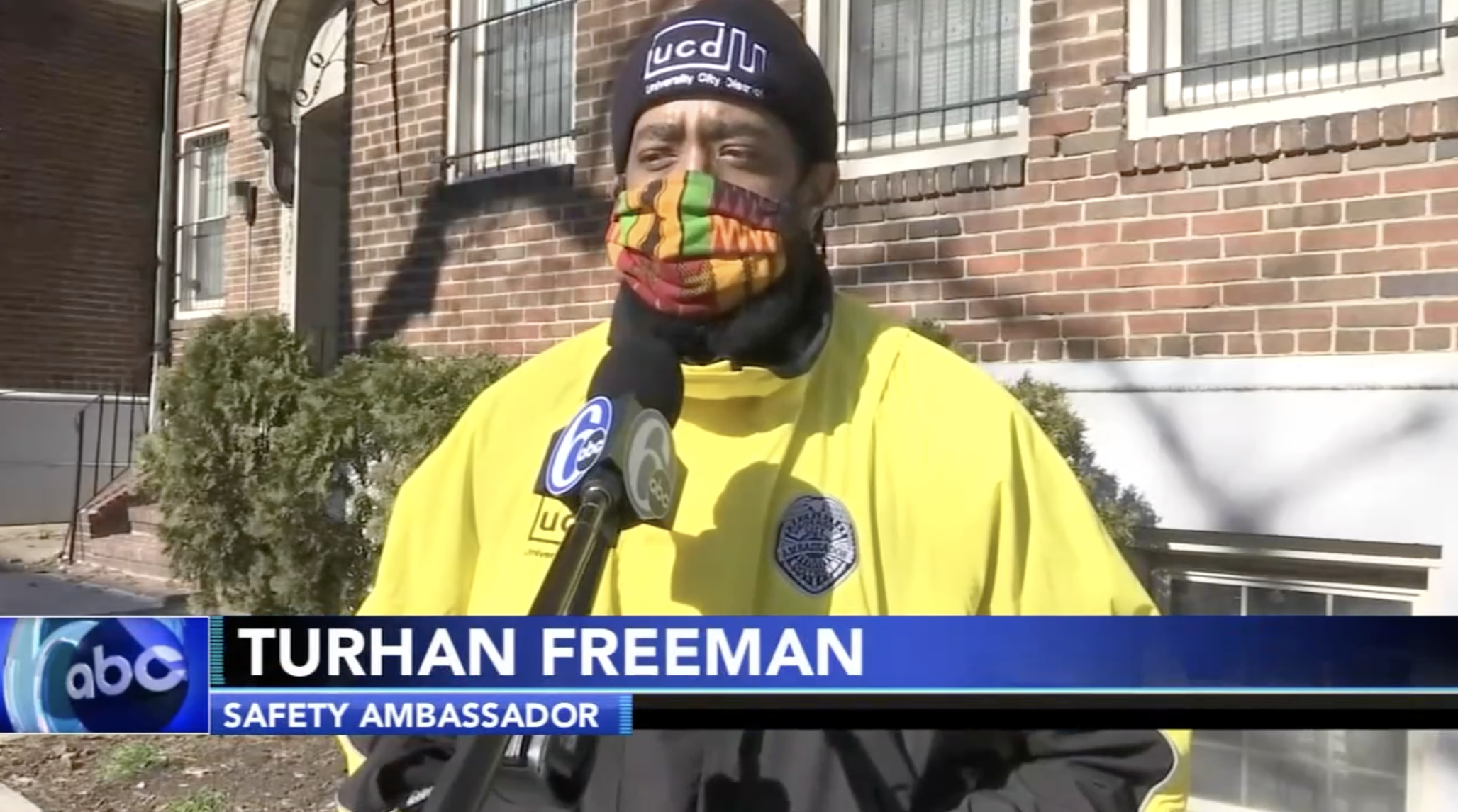 A UCD Safety Ambassador is interviewed by a reporter while standing on the street