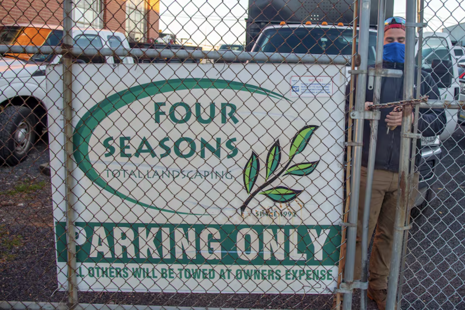 Four Seasons Total Landscaping sign hanging on a fence