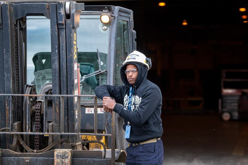 A Shipyard worker standing near equipment.