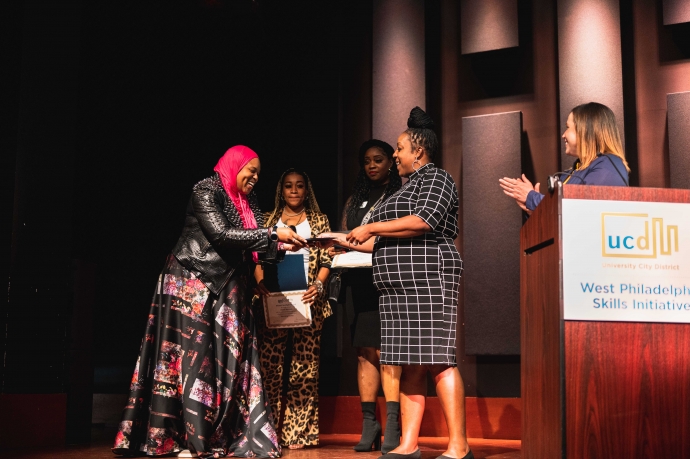 Skills Initiative graduates stand on stage during the tenth anniversary ceremony.