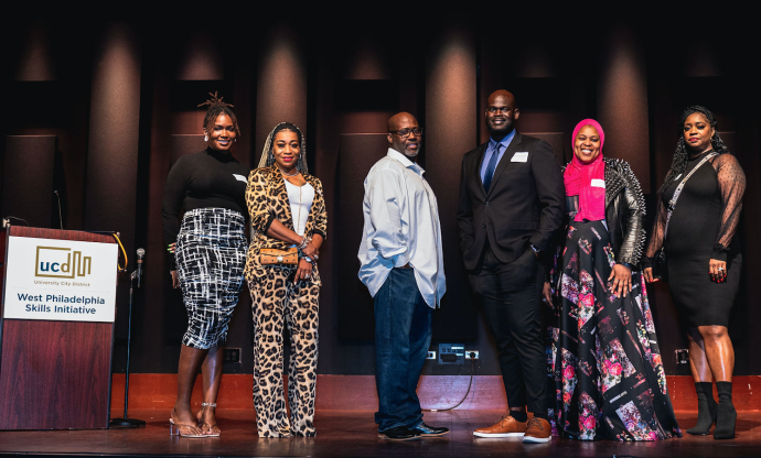 Skills Initiative graduates stand on stage during a graduation ceremony.