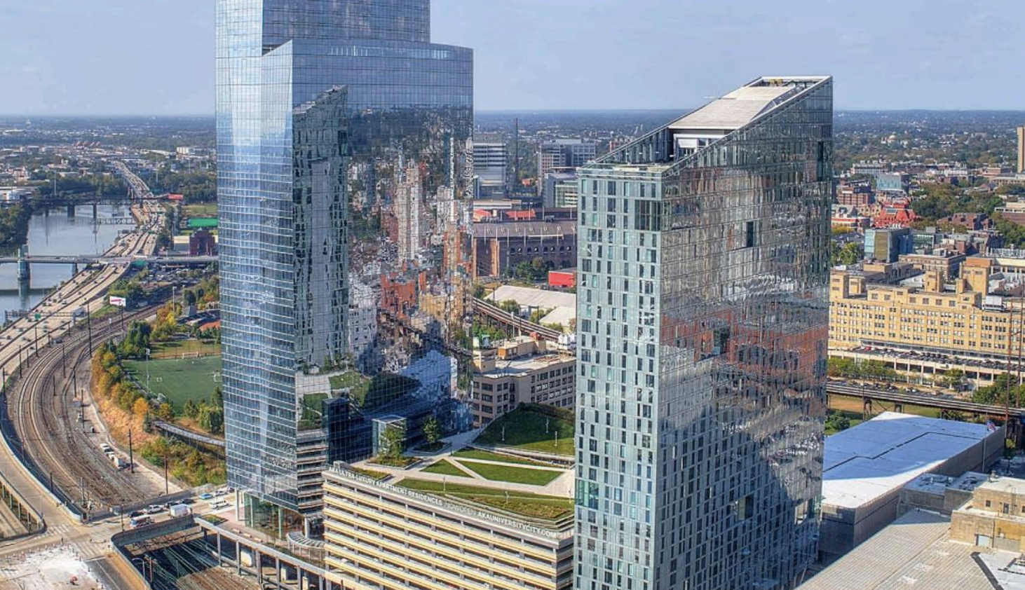 State of University City 2018 header. Features a birds eye view of2 shiny sky scrapers at Schuykill Yards