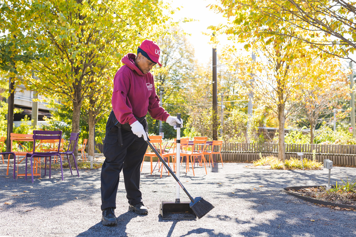 A UCD Cleaning Crew member sweeps the street.