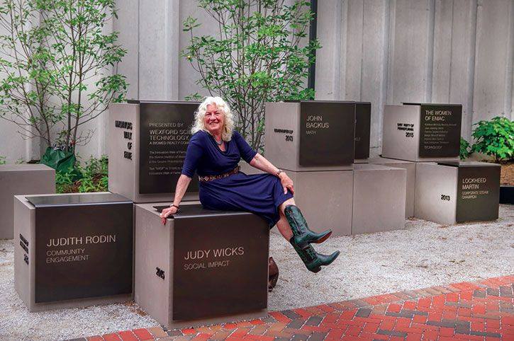 Judy Wicks of White Dog Cafe poses atop a block named after her in Innovation Plaza