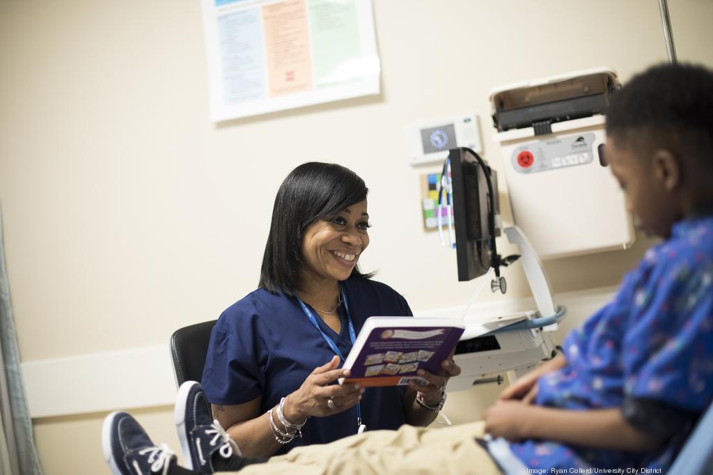 A Patient Care Technician reads to a child patient at a hospital